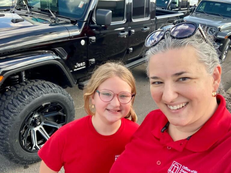 Dawn Palmer and daughter in front of a Jeep.