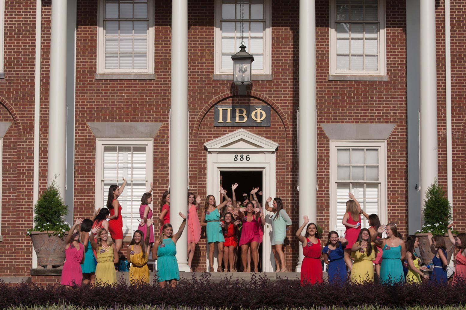 Multiple students in front of a Fraternity.