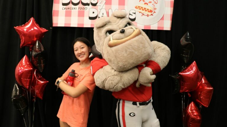 A student posing with Hairy Dawg.