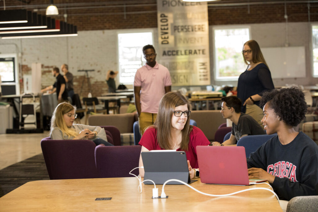 Multiple students working on their laptops together.
