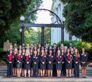 Over a dozen UGA students in formal uniforms in front of the Arch.