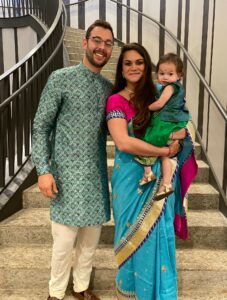 Nidhi Patel with her husband holding her kid.