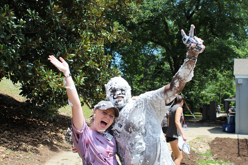 A photo of two students. One of them is covered in spray paint.