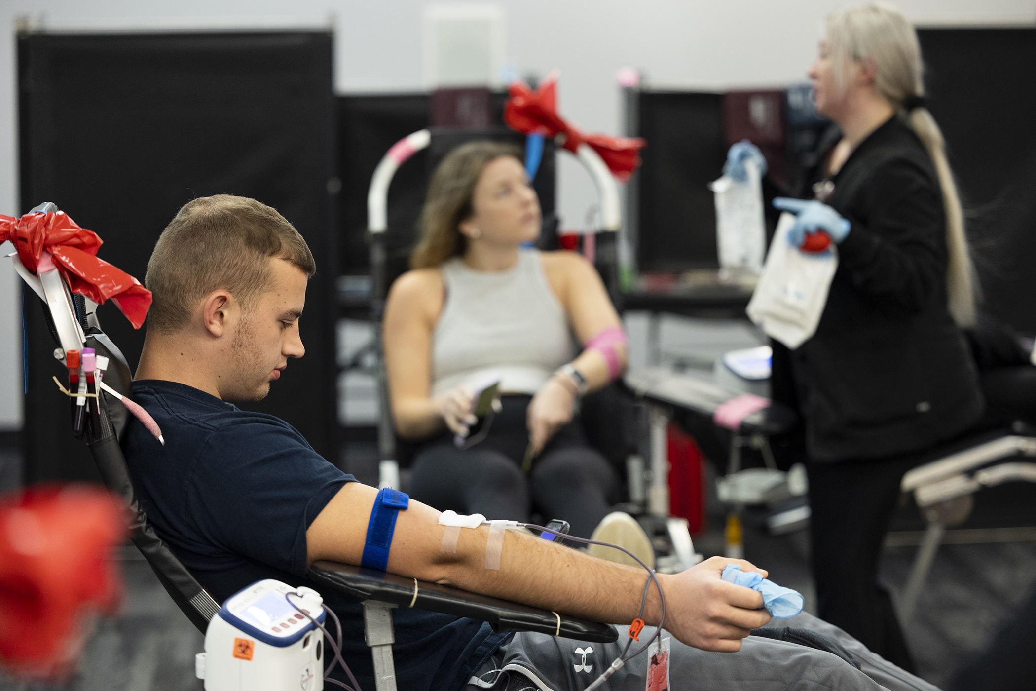 Two people in chairs ready to give blood for a blood drive.