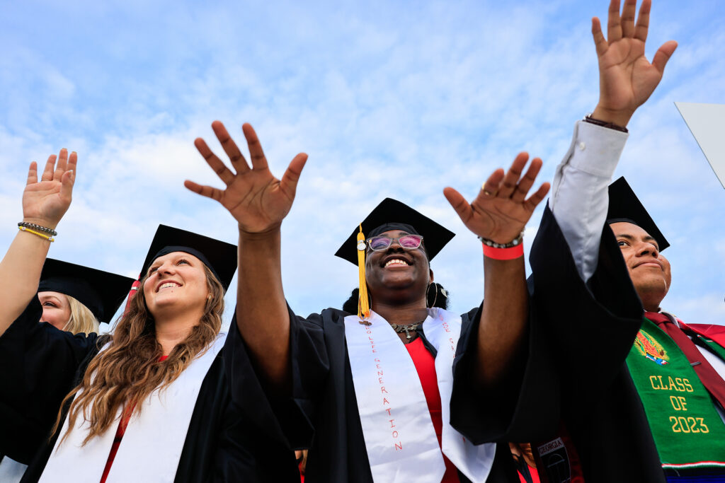 Three students outside on graduation.