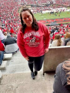 Woman standing with the Sanford Stadium behind her.