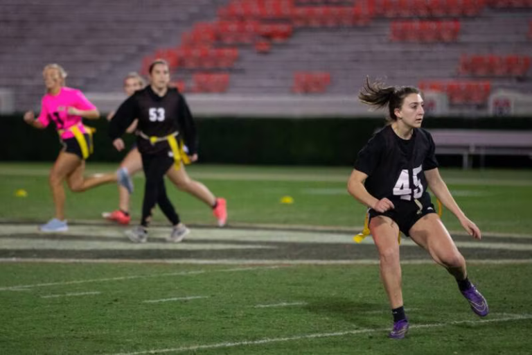 Multiple women playing flag football.