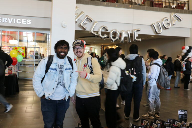 Two male students smiling in Tate Atrium
